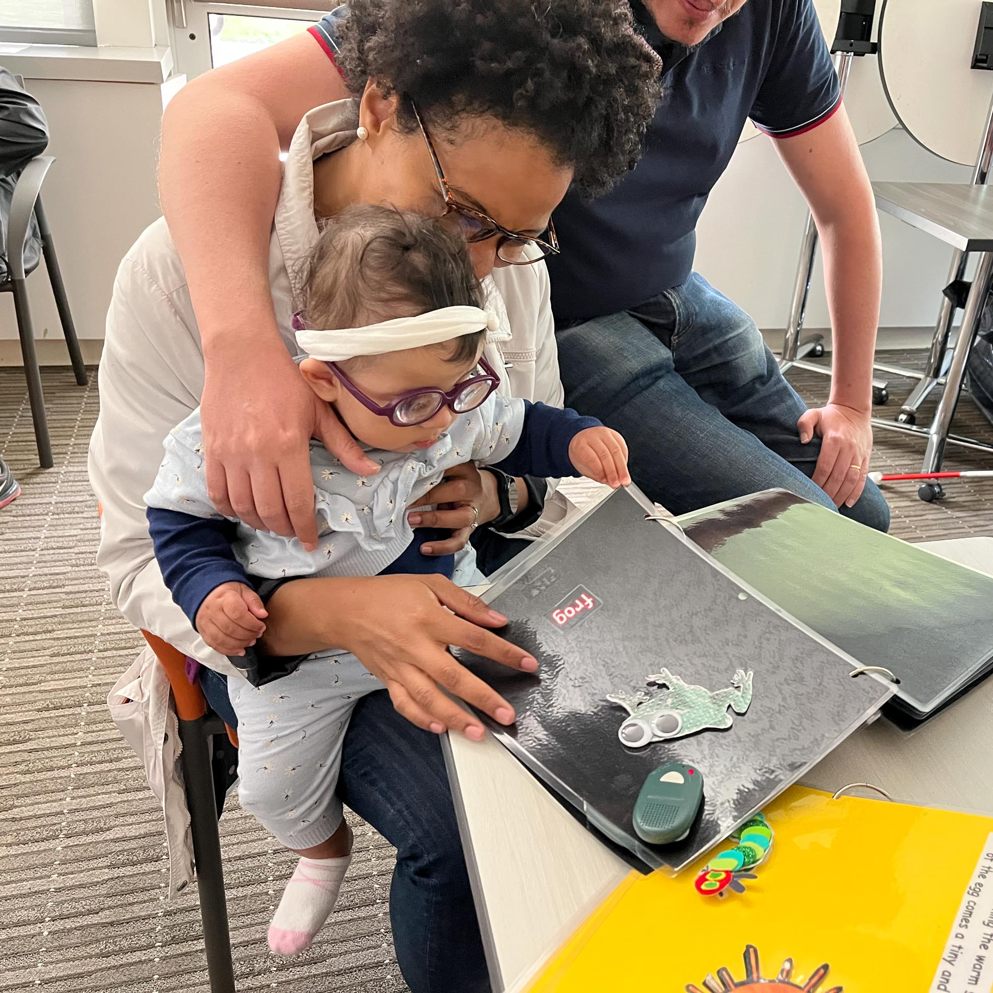 Photo of an instructor working with a young boy on reading Braille.