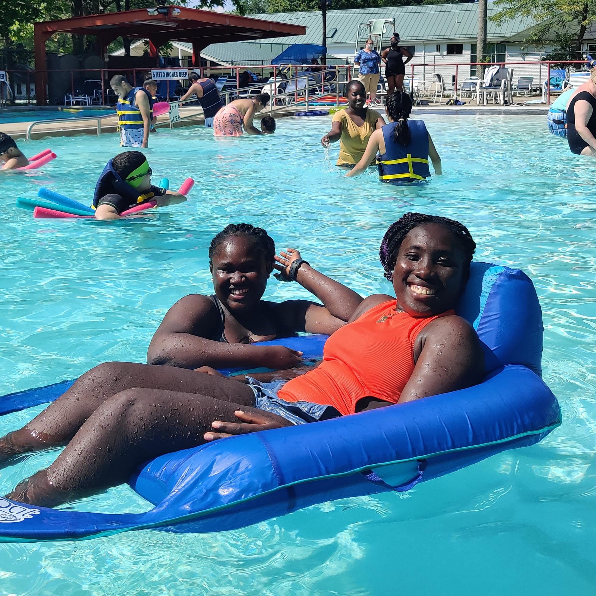 Photo of two VCB participants sitting in large blue pool floaties at VCB