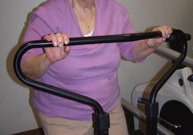 older lady in pink on old school workout equipment