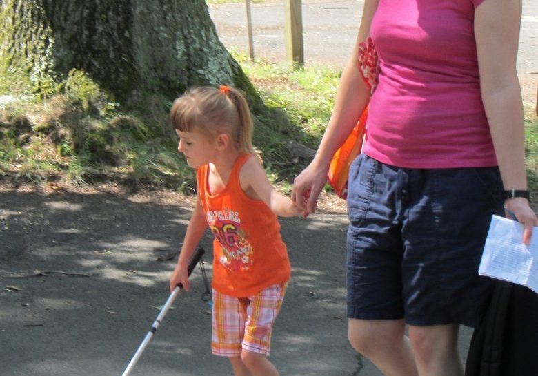 little girl learning how to walk with a can