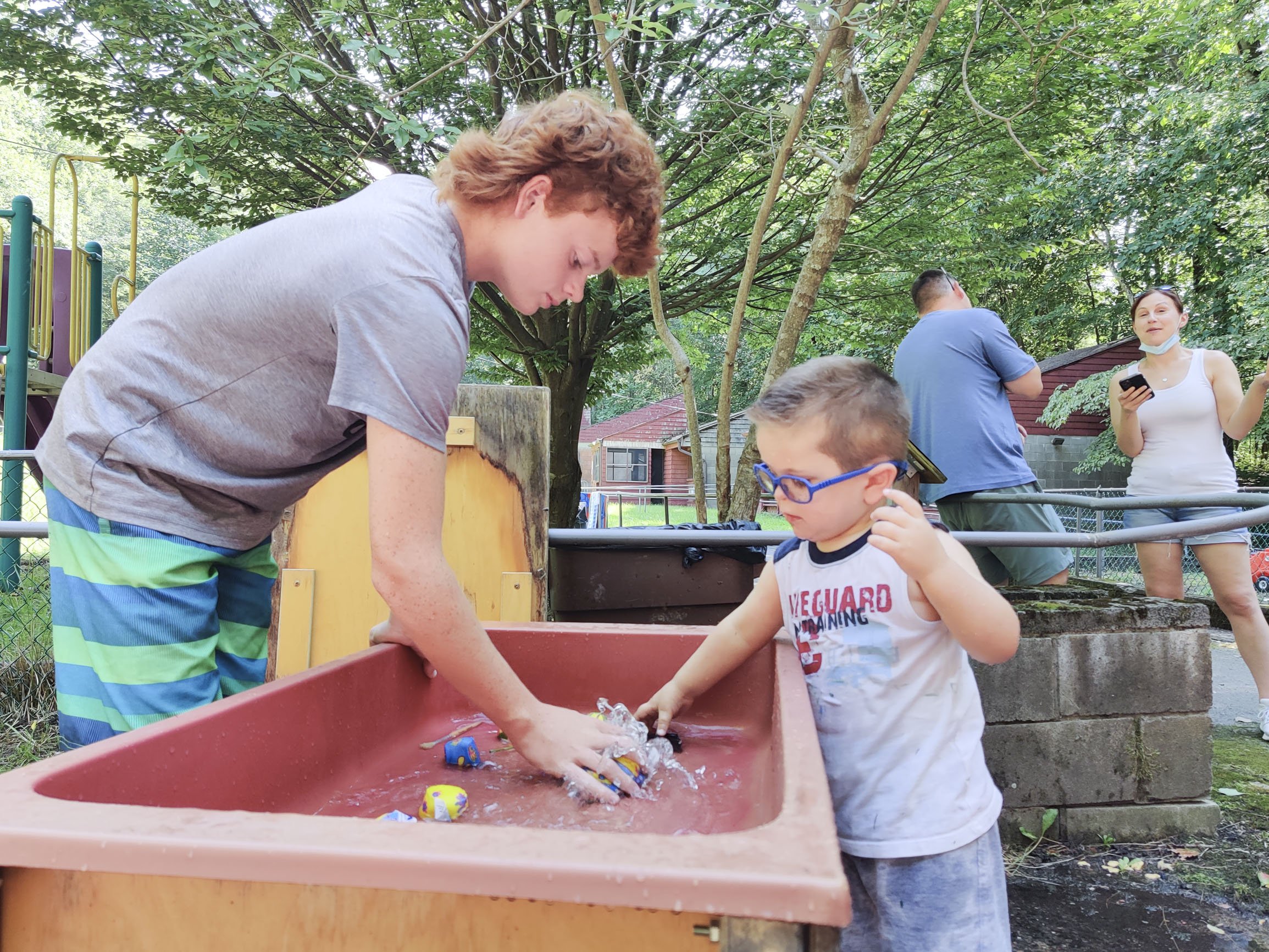 A vision rehabilitation instructor engages in sensory play with a toddler.
