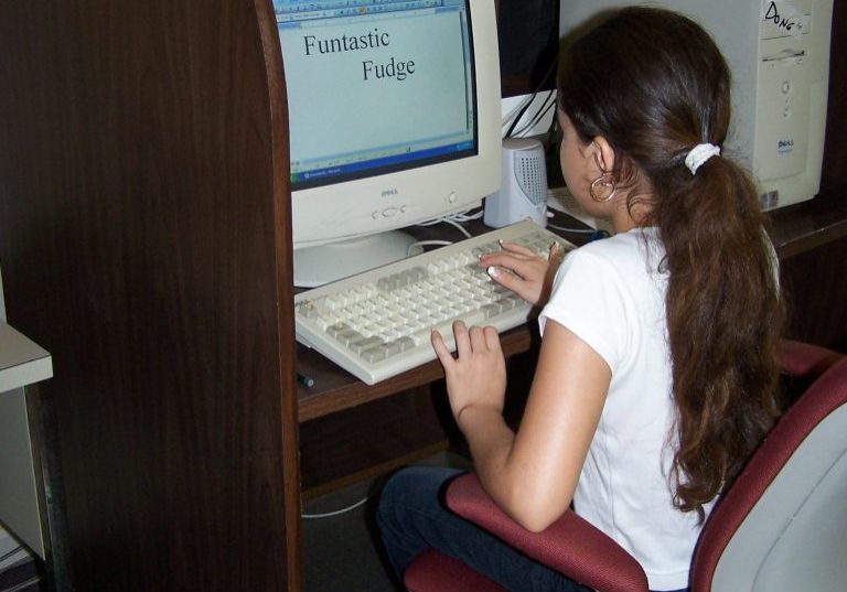 child learning how to operate a computer